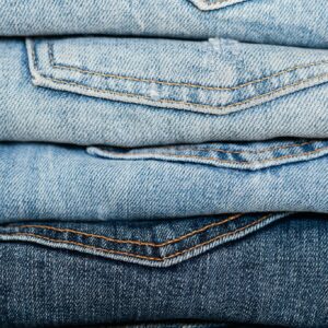 Stack of blue jeans arranged by color
